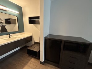 A modern bathroom with a sink, mirror, and dark cabinetry.