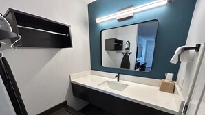 A modern bathroom with a white sink, a mirror, and a towel rack. - 3 Budget-Friendly Rooms | Redondo Beach Station - 3 miles | Pets Allowed (Gardena)