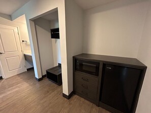 A compact kitchen with a microwave, a small refrigerator, and a built-in oven.