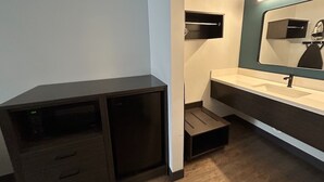 Une salle de bain moderne avec un meuble sombre, un lavabo et un miroir.