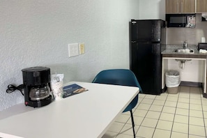 Eine kleine Küchenzeile mit Kaffeemaschine, Spüle und Mikrowelle.