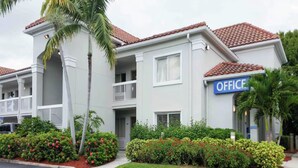 A two-story building with a sign reading 'OFFICE' on the right side. - Budget-Friendly Room w/ Kitchen | 3 Miles to Downtown | Free Parking | Pets OK (West Palm Beach)