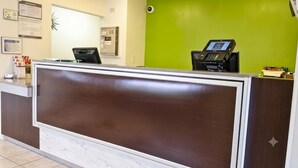 A reception desk with a digital kiosk, a marble-tiled floor, and a green wall. - Budget-Friendly Room w/ Kitchen | 3 Miles to Downtown | Free Parking | Pets OK (West Palm Beach)