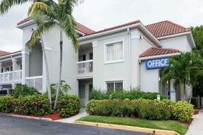 Un edificio a due piani con un cartello che riporta la scritta 'OFFICE' sul lato destro.