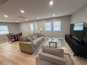 A living room with a sofa, a coffee table, a TV, and a dining area with chairs and a table. - Peaceful 3-bedroom house with AC in charming La Porte, bring you peace and quiet (La Porte)