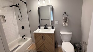 Un baño moderno con ducha, inodoro y tocador.