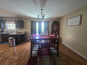A dining area with a wooden table, chairs, and a chandelier.