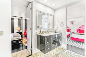 A modern bathroom with a large mirror, a vanity with a sink, and a shower area. - Luxury Deepwell Stunner (Palm Springs)