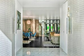 Ein modernes Interieur mit Marmorboden, einer Essecke mit blauen Stühlen und einem Kronleuchter.