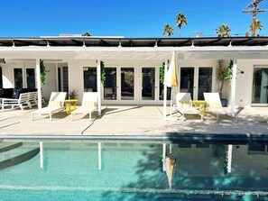 A modern building with a pool, white lounge chairs, and a covered patio area. - Puerta Del Sol - Tahquitz River Estates (Palm Springs)