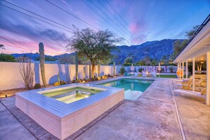 Un espace piscine doté d’un jacuzzi, de chaises longues et offrant une vue sur les montagnes.
