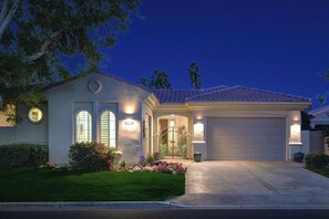 A residential house with a garage, a well-maintained lawn, and a driveway. - PGA West Paradise by Oranj Palm (La Quinta)