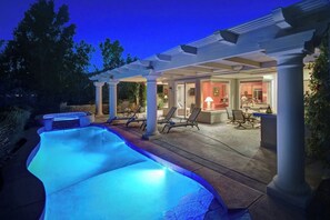 Piscina aquecida com espreguiçadeiras e um espaço coberto com varanda.