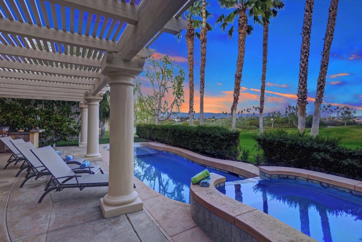 A pool area with lounge chairs and a pergola.