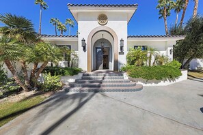 A two-story house with a tiled entrance, a balcony, and a well-maintained garden with palm trees. - Casa Sueños - Andreas Hills (Palm Springs)