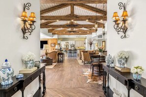A spacious interior with a high ceiling, wooden beams, and a central dining area. - Casa Sueños - Andreas Hills (Palm Springs)