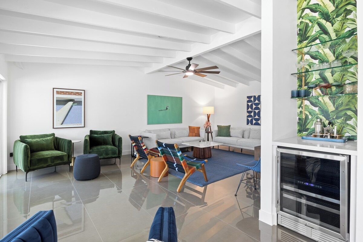 Ein modernes Wohnzimmer mit weißer Decke, grünen Sesseln, einem Sofa und einem Couchtisch.
