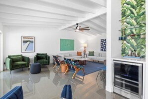 A modern living room with a white ceiling, green armchairs, a sofa, and a coffee table. - Sun & Stone Retreat (Palm Springs)
