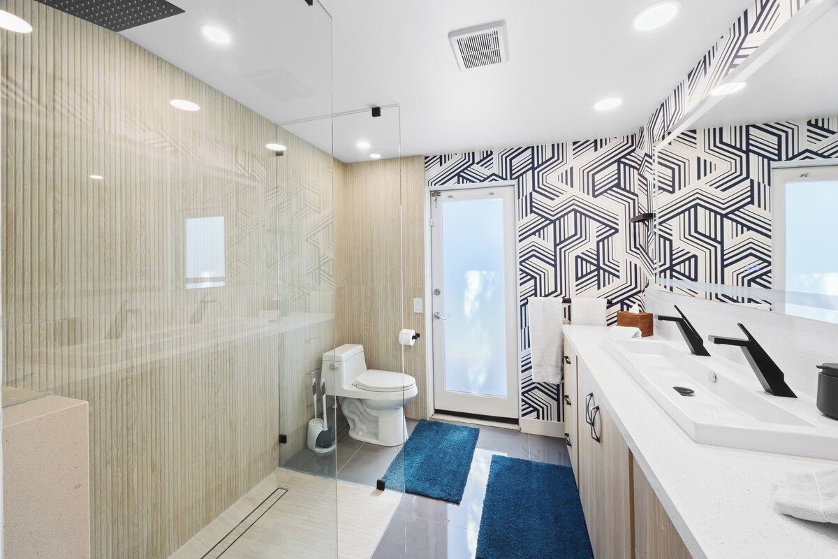 Un baño moderno con inodoro, lavamanos y zona de ducha.