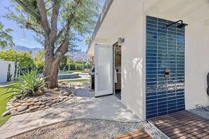 A modern outdoor area with a pool, a tree, and a patio with a stone pathway. - Sun & Stone Retreat (Palm Springs)