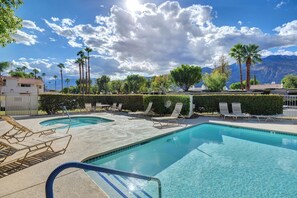 A swimming pool with lounge chairs and palm trees, surrounded by a hedge and mountains in the background. - Mesquite WorkPlay Oasis - Central PS (Palm Springs)
