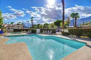 A swimming pool with lounge chairs and palm trees, surrounded by buildings and mountains. - Mesquite WorkPlay Oasis - Central PS (Palm Springs)