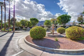 A landscaped garden with a fountain, palm trees, and a mountain backdrop. - Mesquite WorkPlay Oasis - Central PS (Palm Springs)