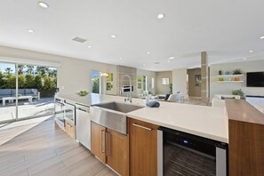 A modern kitchen with a dishwasher, oven, and a large island. - Mountain Views Luxury Oasis: Pool, Hot Tub, BBQ (Palm Springs)