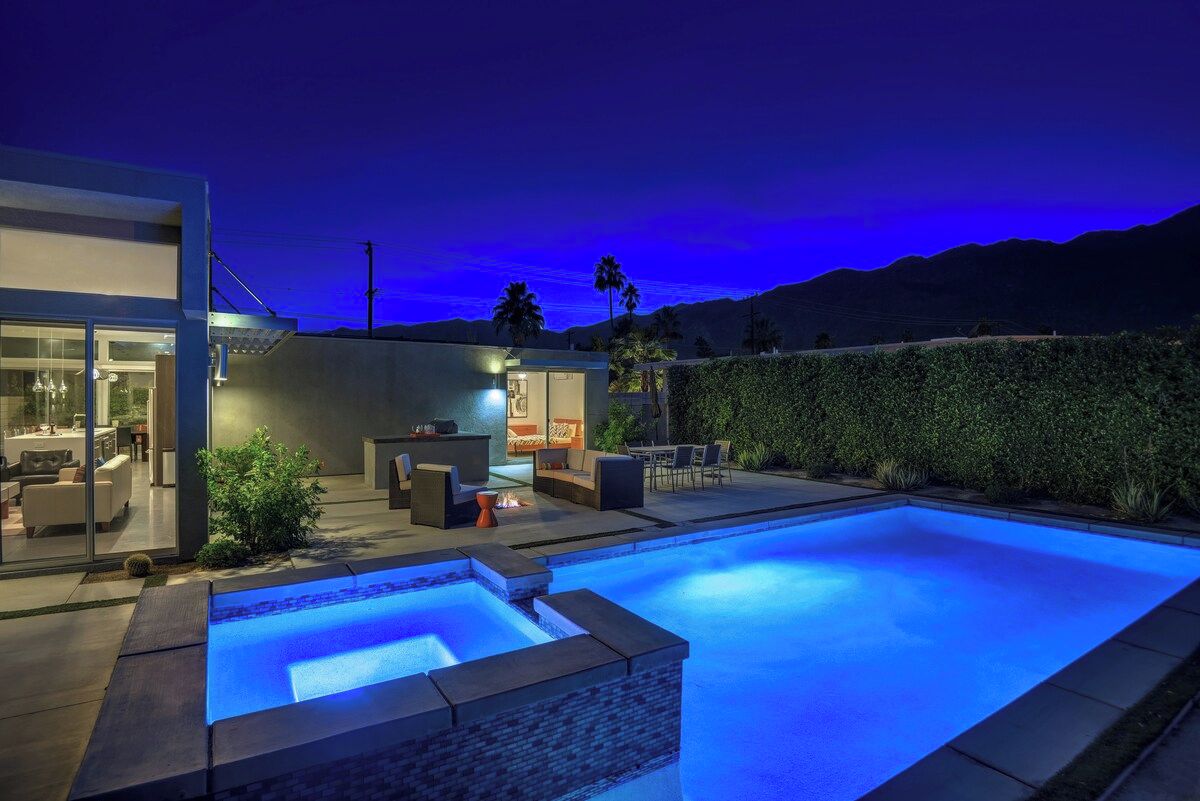 Una casa moderna con piscina, area relax esterna e vista sulle montagne.