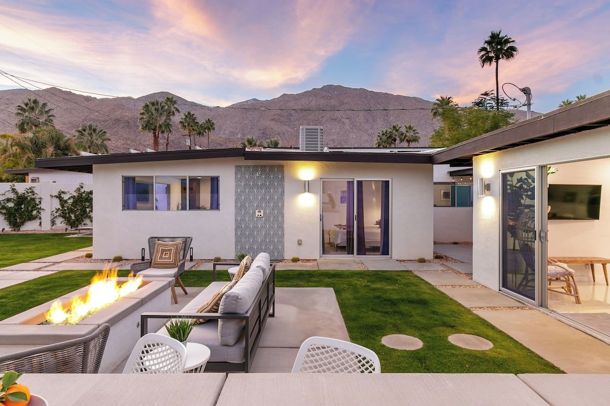 A modern house with a patio, outdoor seating, and a fire feature.