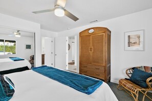 A bedroom with a bed, a wardrobe, a ceiling fan, and a window. - Retreat on Mesquite - South PS (Palm Springs)