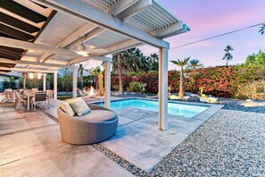 Ein überdachter Außenbereich mit Pool, Sitzgelegenheiten und einer Terrasse.