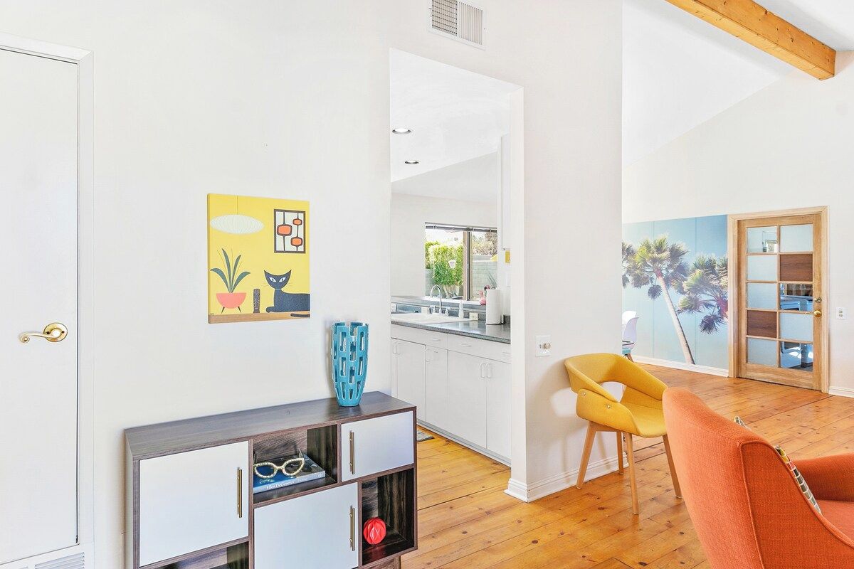 Una sala de estar moderna con suelo de madera, un sofá, una mesita y un mueble de pared.