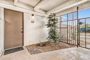 A gated entrance with a door marked '101,' a small plant, and a metal gate. - Ocotillo Art Lounge - Historic Ocotillo Lodge (Palm Springs)