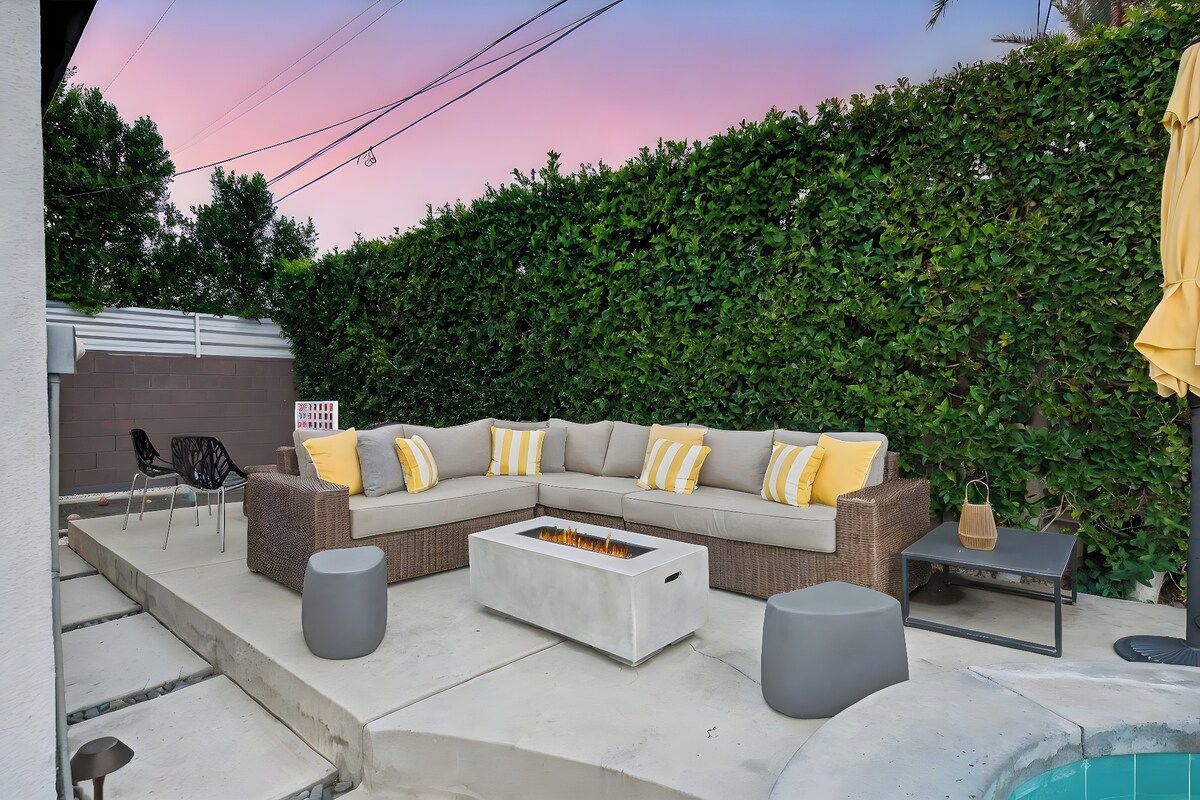 An outdoor seating area with a fire pit, a sofa, and a table.