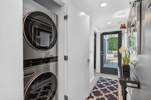 A hallway with a double oven, a patterned rug, and a door leading to an outdoor area. - Yellow Palms - Warm Sands (Palm Springs)