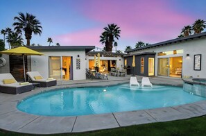 A modern pool area with lounge chairs, a hot tub, and a patio with umbrellas. - Yellow Palms - Warm Sands (Palm Springs)