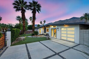 A modern house with a garage, a well-maintained lawn, and palm trees. - Yellow Palms - Warm Sands (Palm Springs)