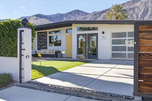 A modern house with a garage, a well-maintained lawn, and a mountain backdrop. - Yellow Palms - Warm Sands (Palm Springs)