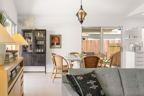 Eine moderne Küche mit Essbereich, einer Couch und einem Esstisch mit Stühlen.