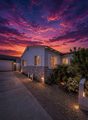 A two-story house with a garage, a stone facade, and a well-lit driveway. - 2BR coastal San Diego home near the pier (San Diego)