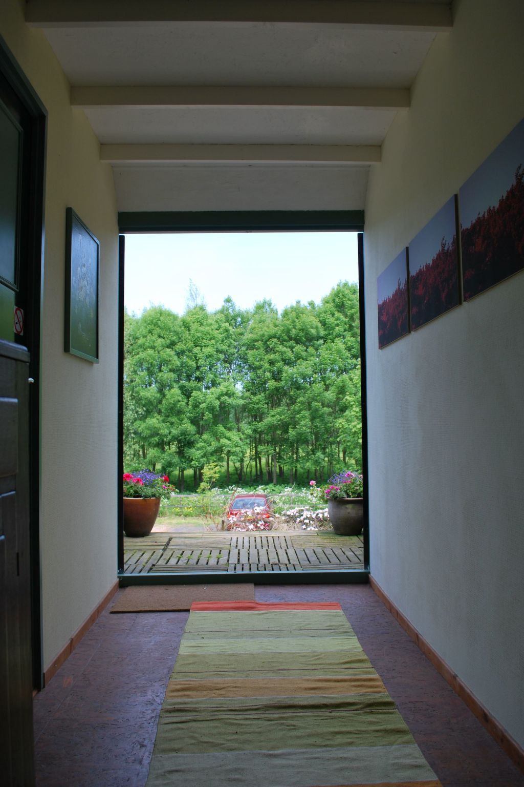 A hallway with a view of a forested area outside.