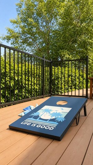 A blue board game on a wooden deck with a black metal fence in the background. - Woodland Hills Hidden Waterfall Oasis | Pool & BBQ (Los Angeles)