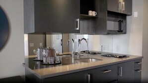 A modern kitchen with a large island, stainless steel appliances, and dark cabinetry. - Dominion Grand Suites Toronto (Toronto)