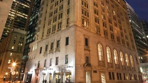 A historic building with multiple floors, large windows, and a prominent corner location in a cityscape. - Dominion Grand Suites Toronto (Toronto)
