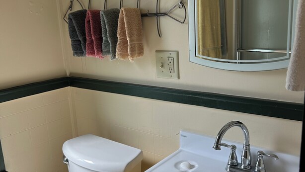 Ein Badezimmer mit Toilette, Waschbecken und Handtuchhalter.