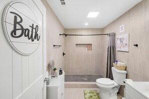 A modern bathroom with a shower, toilet, and sink. - Backyard Breeze: Modern 1BR with Walk-In Shower Near BNA (Nashville)