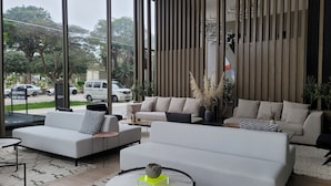Ein modernes Wohnzimmer mit einer Sofagarnitur, einem Couchtisch und Blick auf die Straße.