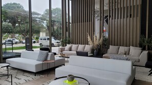 Una sala de estar moderna con un juego de sofá, una mesa de centro y vistas a la calle.