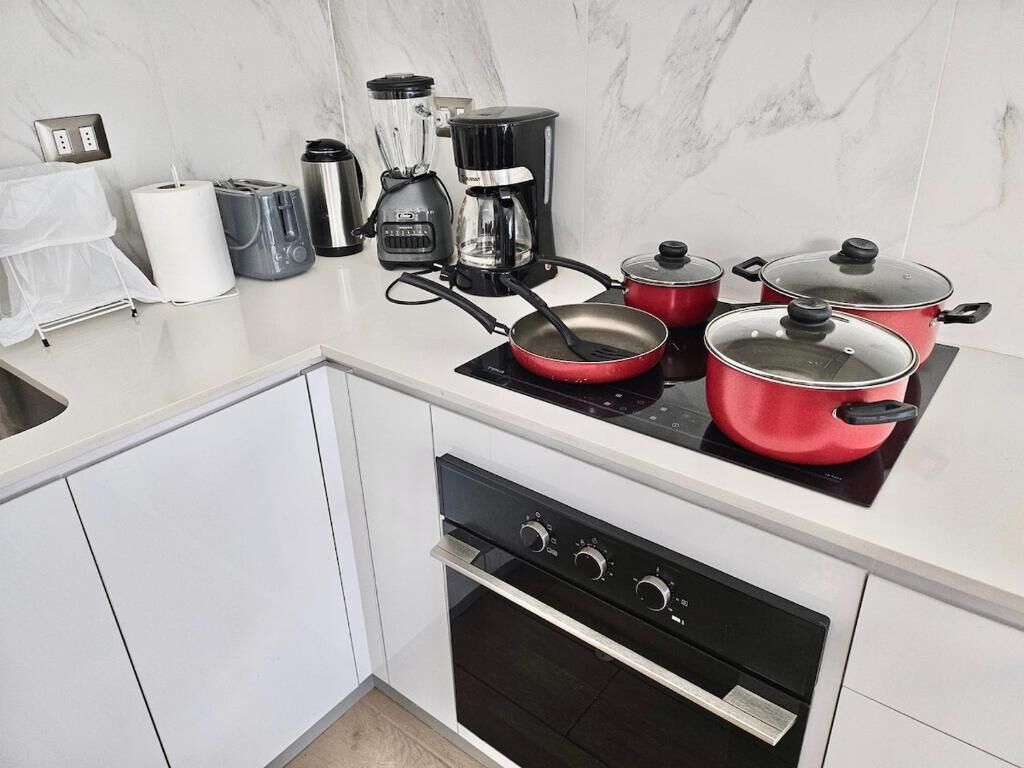 Eine moderne Küche mit einem Gasherd, zwei Töpfen, einer Kaffeemaschine und einem Toaster.